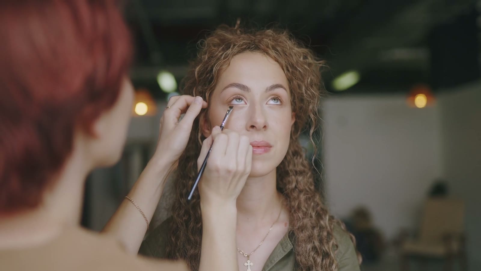 Makeup artist applying eye makeup to a client